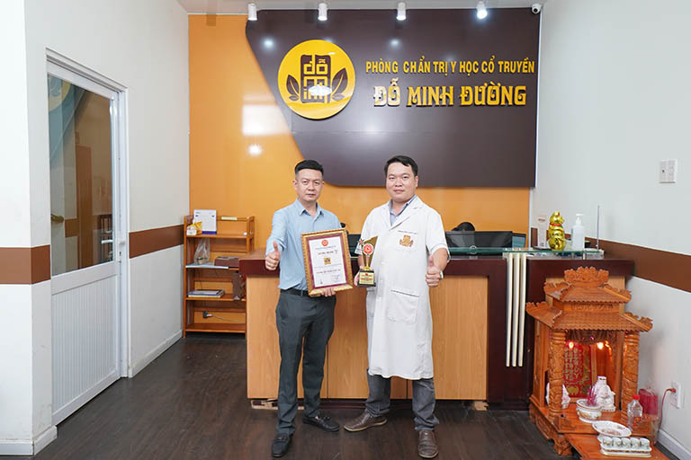 Lương y Tuấn và lương y Lâm đang cầm trên tay giải thưởng Top 10 Thương hiệu mạnh Quốc gia năm 2024 của Nhà thuốc Đỗ Minh Đường